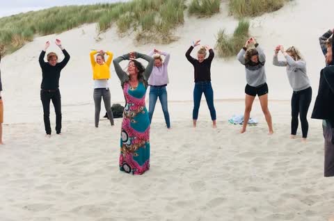 Groepsles yoga op het strand